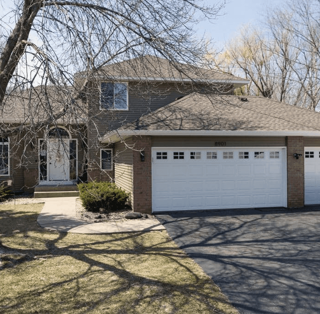 A house with new light brown siding and a two car garage.