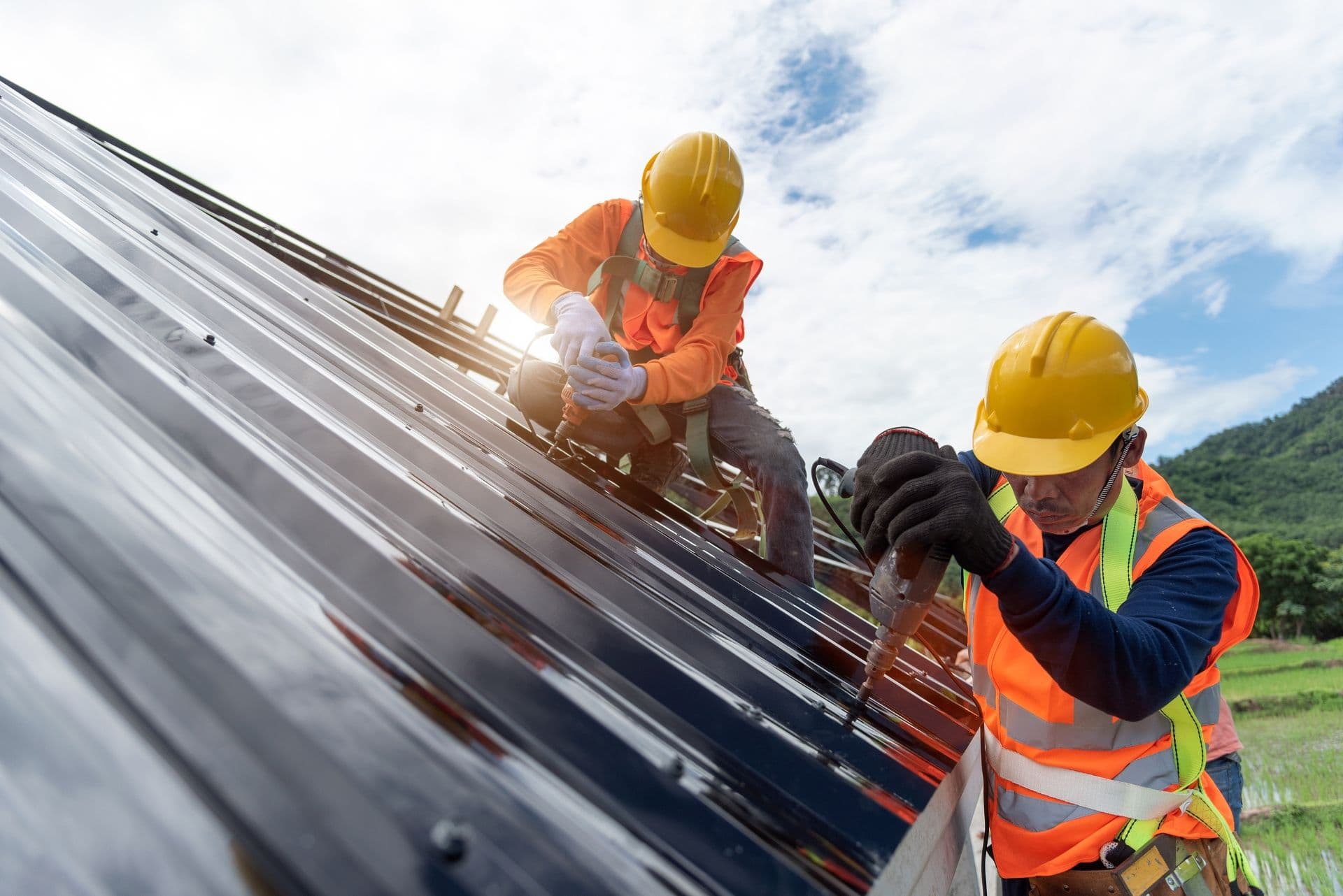 Workers install metal roofing.