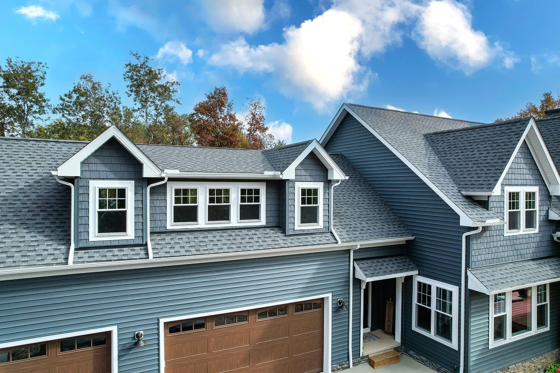 A house with blue siding and new ProVia windows with white trim.