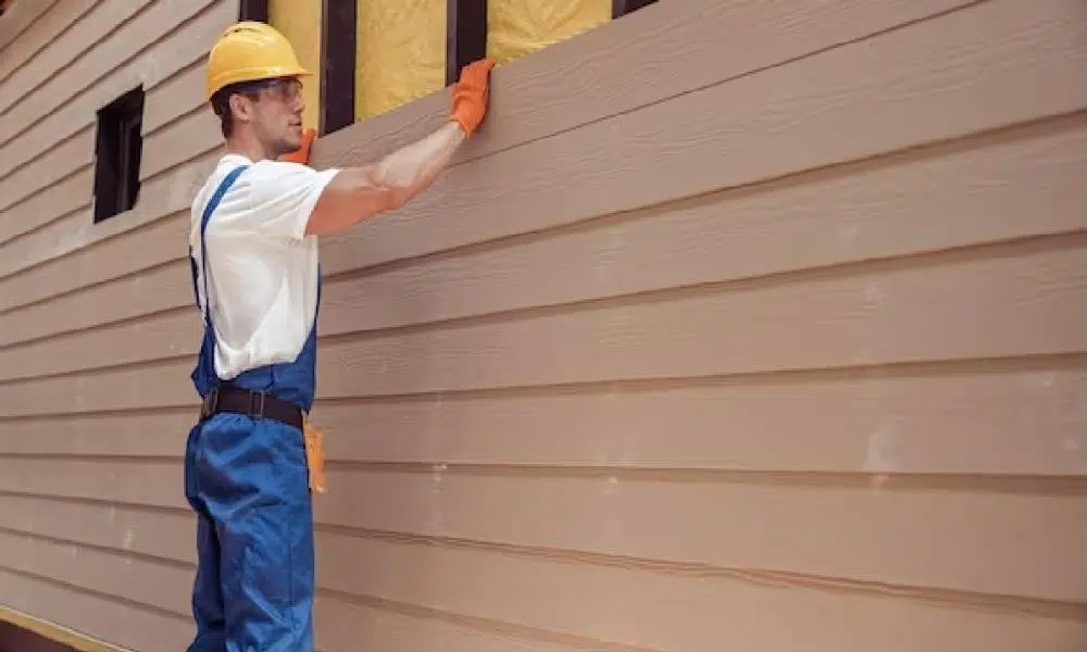 Construction worker installing house siding