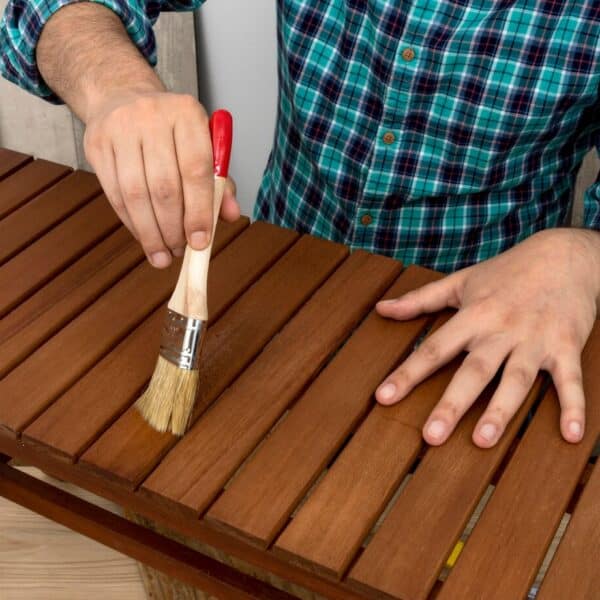 Person staining wooden furniture
